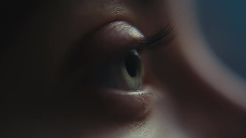 A person blinks their eye as they stare into the distance