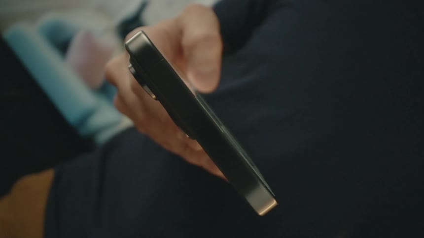 A man is scrolling on his phone using only one hand