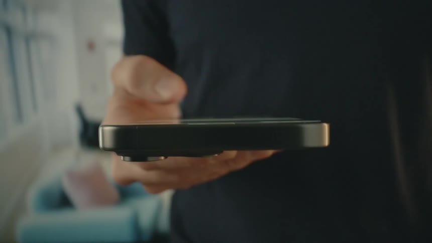 Man wearing a black tshirt is using his iphone