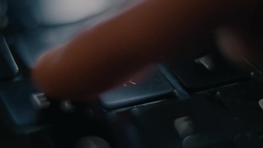 Index finger clicking a laptop key