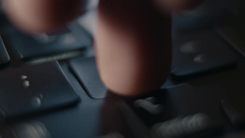 Fingers typing on a laptop