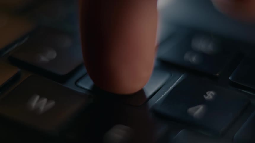 A person uses their finger to press a number on a keyboard