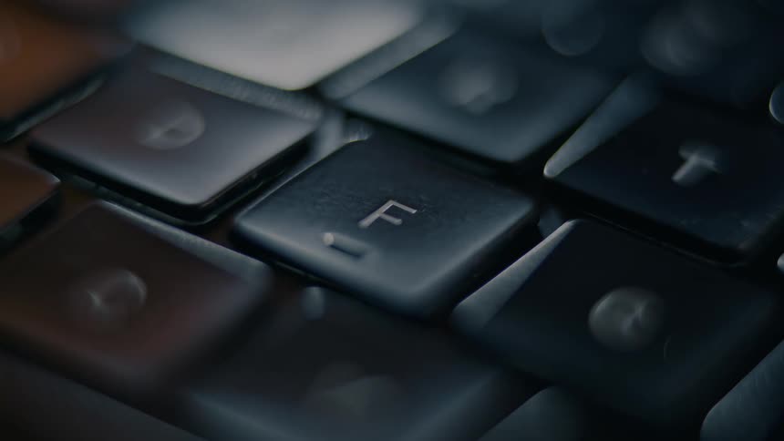A finger pressing the f key on a keyboard