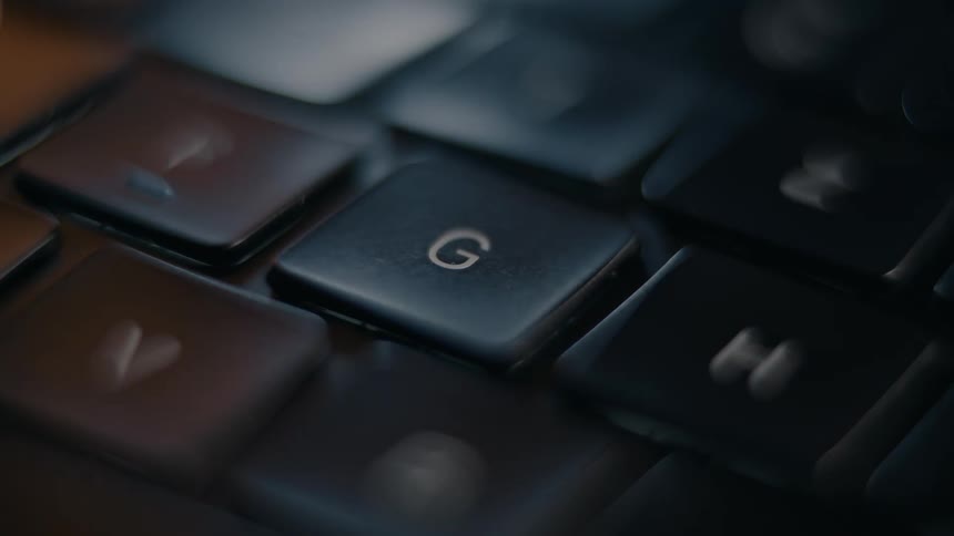 A finger pressing the g and i key on a keyboard