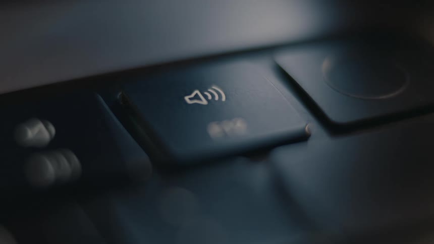 Person repeatedly hits the volume key on a keyboard