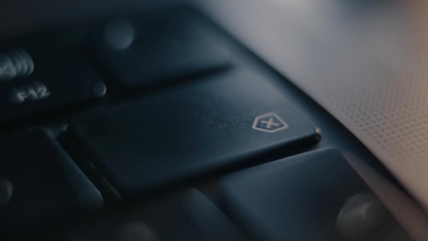 A person uses one finger to keep pressing a button on a keyboard
