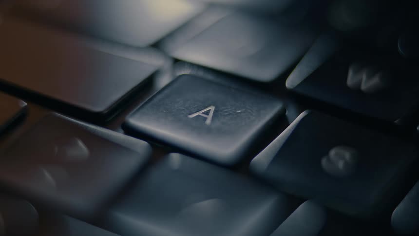 Close up of a finger pressing a key on a laptop keyboard