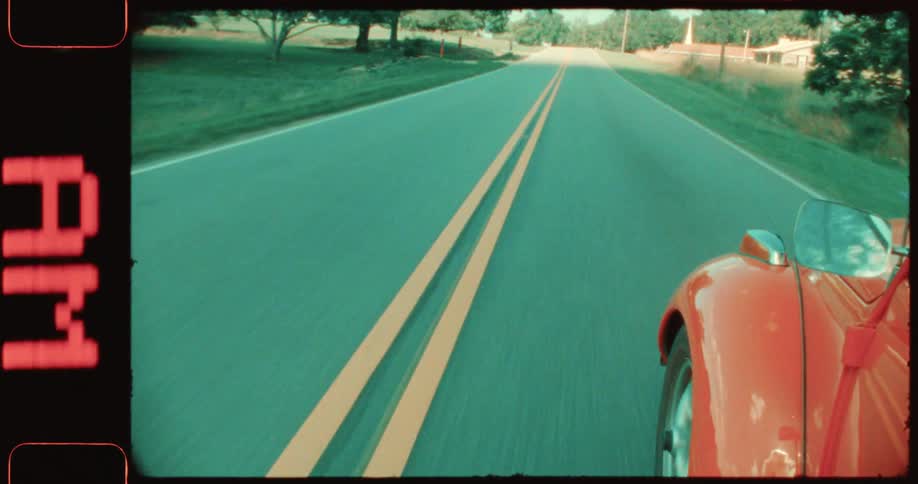 Point of view of a red vintage car moving along the highway