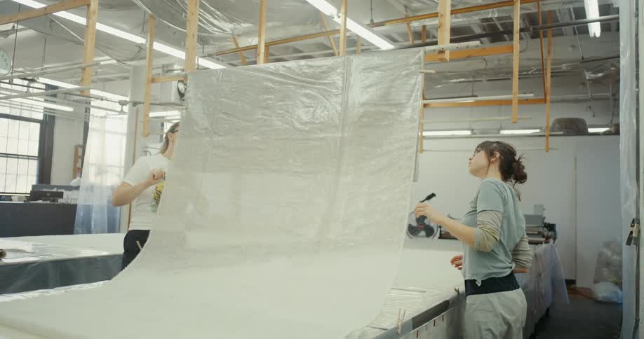 Two women in a textile factory working on a fabric