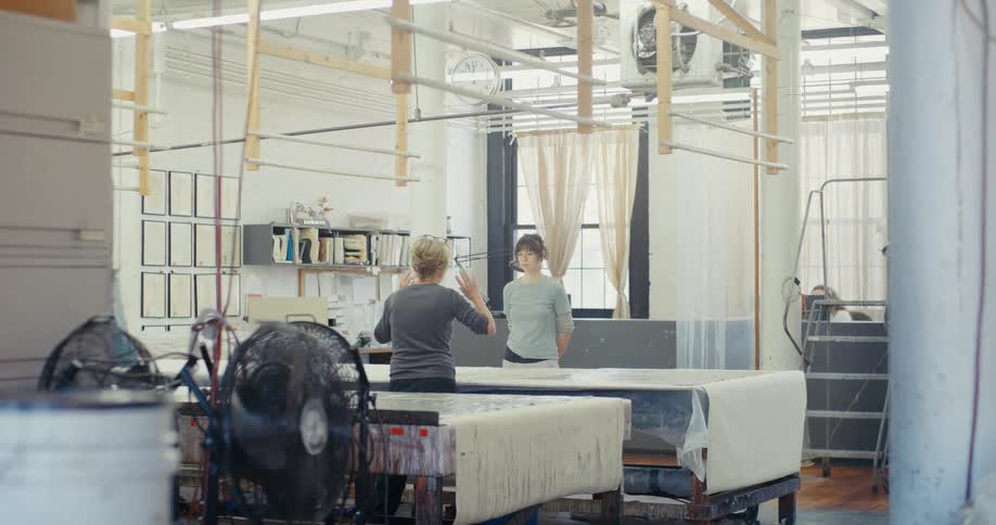 A clip of two people having a discussion in the factory