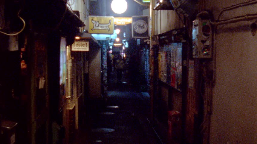People walking down an urban alley at night