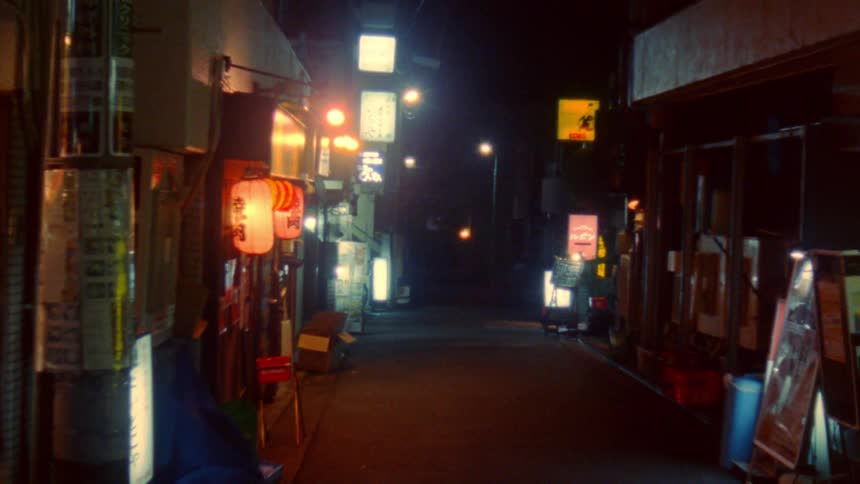 Alley at night lit up with asian shops