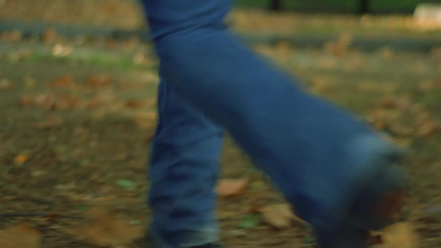Legs of two women in jeans running on the grass