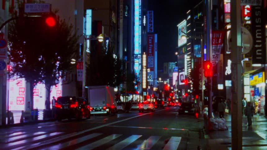 People and cars travel in the city at night