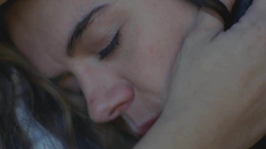Woman laying on another womans shoulder affectionately