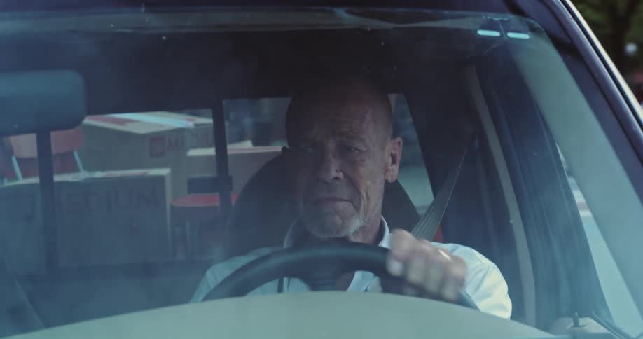 The man turns while driving his truck