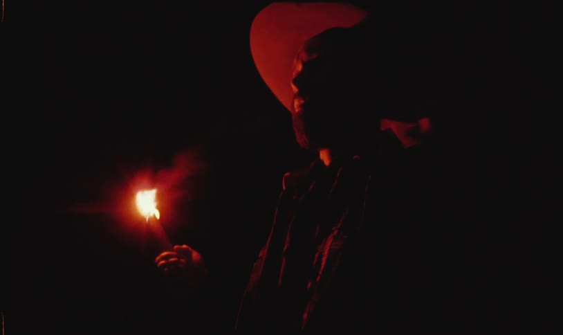 A man is holding a lit flare at night