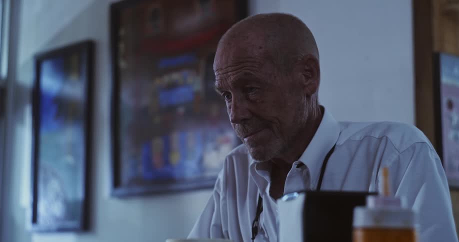 A man is standing in a restaurant looking down