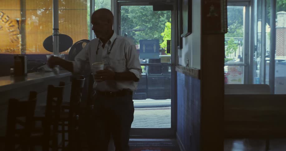 A man opens his shop and enters