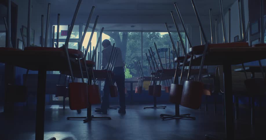 Man with a broom cleaning a room
