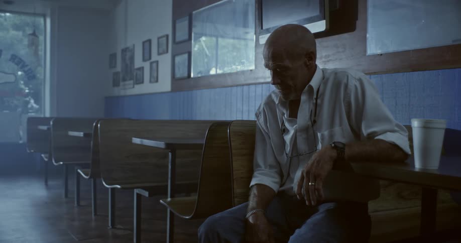 Elderly man sitting at a table in a diner