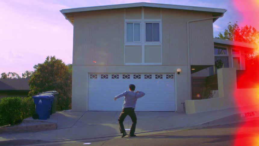 A man is break dancing in front of the home