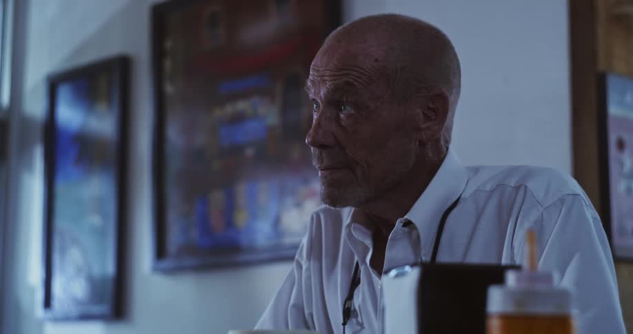 A man walks over to the counter and leans