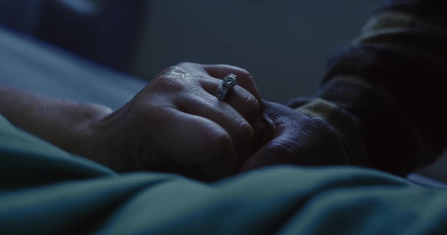 Two people hold hands