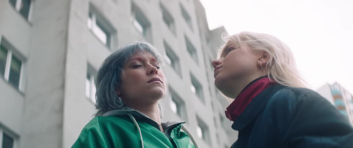 Two women face each other on a cloudy day