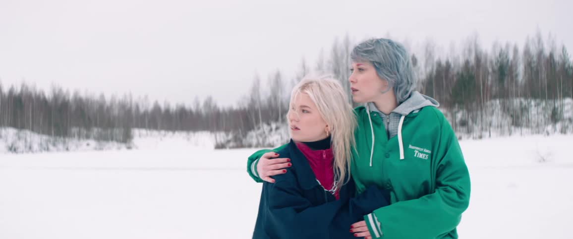 Two women hugging each other walking in a snowy environment