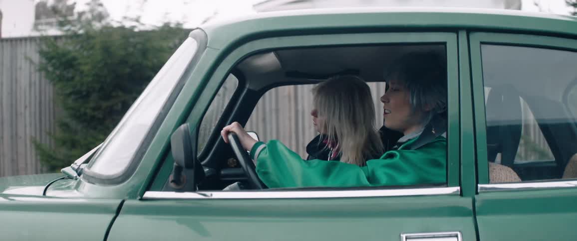Two women ride in a green car