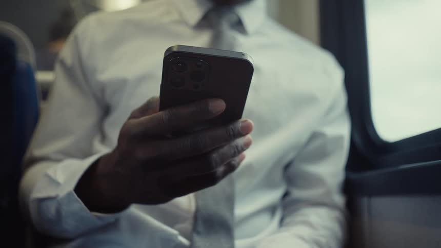 Man riding on a bus scrolls on his smartphone