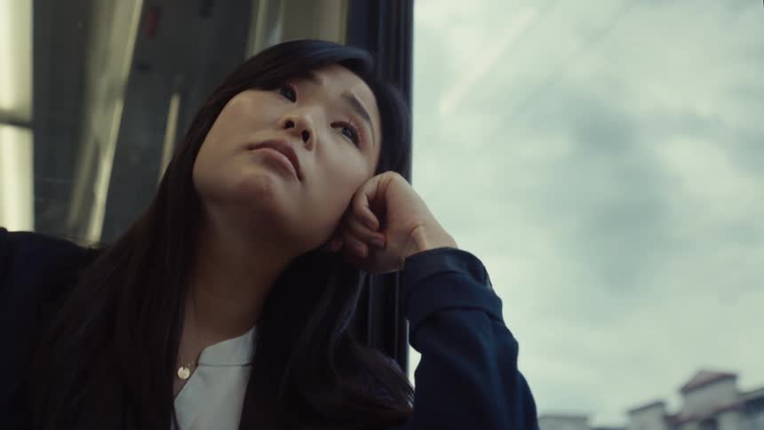A woman gazes out the window while riding in a train