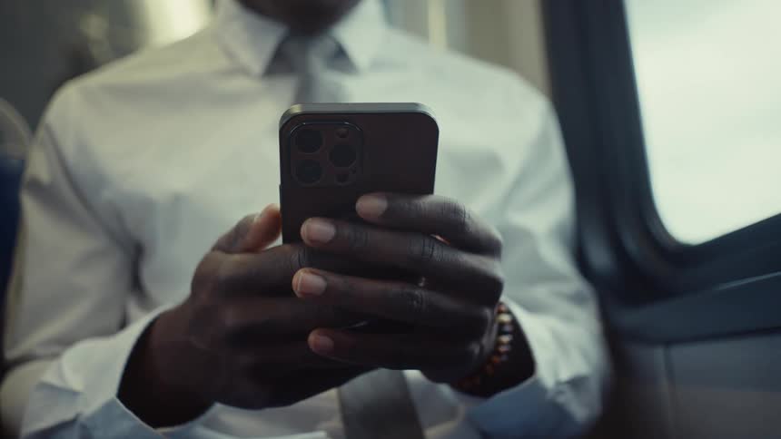 Man uses a smartphone while riding on public transportation