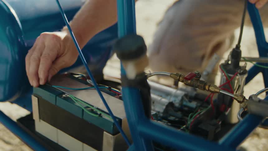 A man tightens the connections on a battery