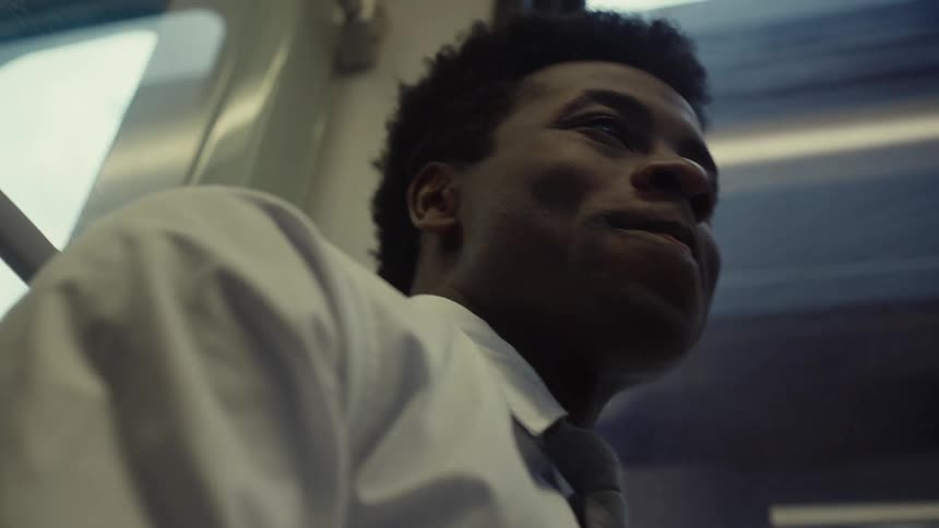 A man smiles while he looks around the moving train