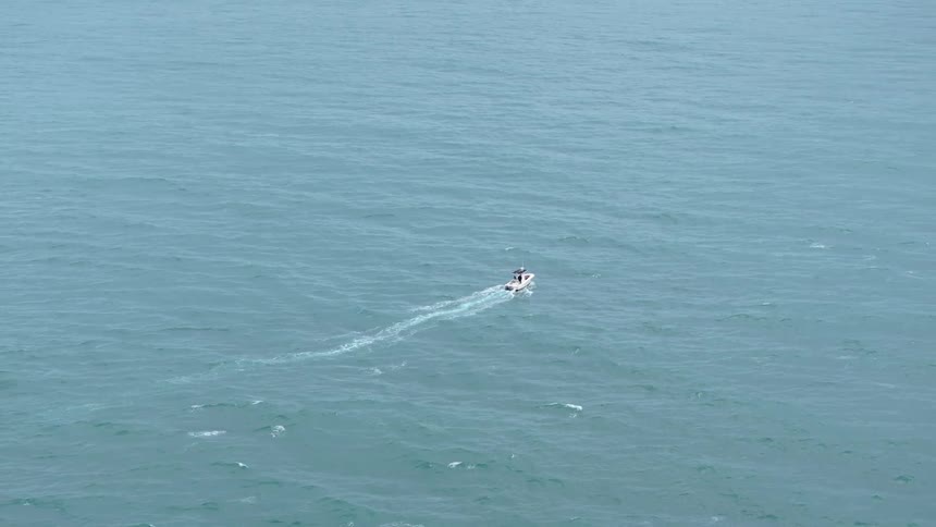 Motorboat moving across the ocean during the daytime leaves a wake