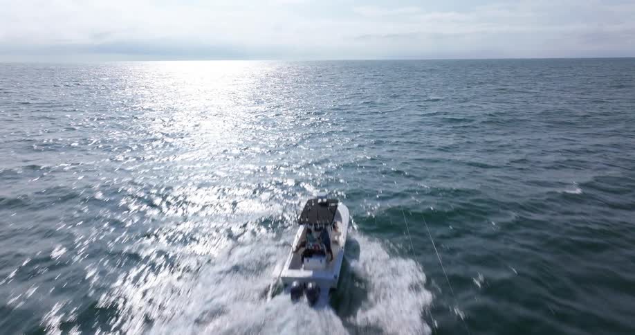 A man is on a small boat on a large body of water