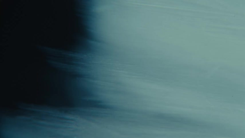 Darkness passes revealing awhite variegated surface