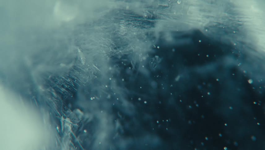 A close up of an icy textured surface with intricate frost patterns and a misty bluish atmosphere evoking a cold and ethereal feeling