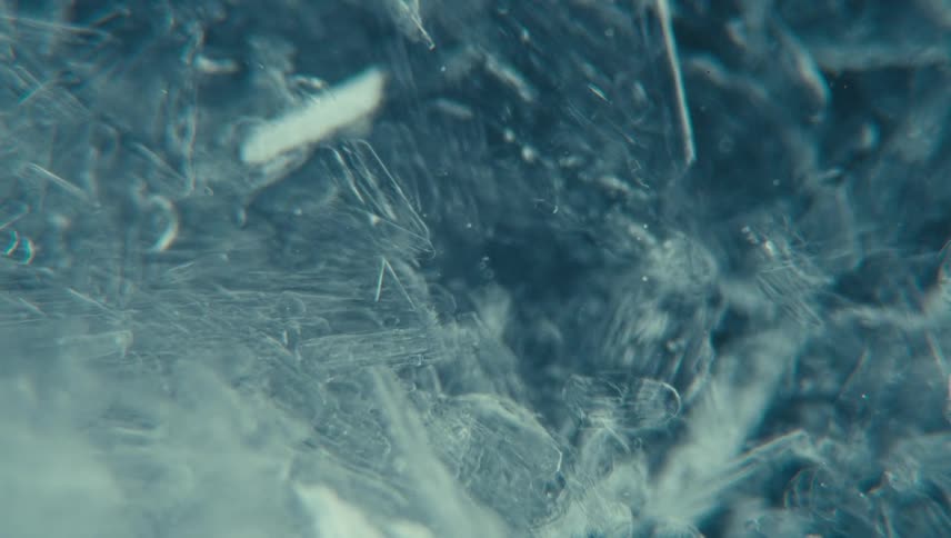 Ice with fine crystals and irregular lines moving in the water