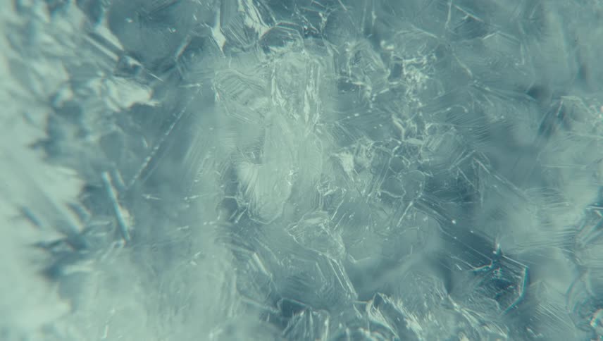 Extreme close up of ice cracks freezing water