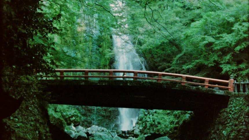 Classic bridge in nature with a background of waterfall and vegetation
