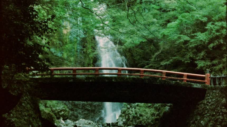 Water flows over a waterfall near a bridge