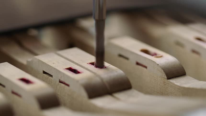 Drill bit drilling a piece of wood with precise cuts