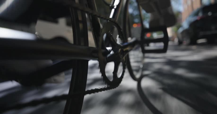 Closeup of a persons feet riding a bicycle on a city street