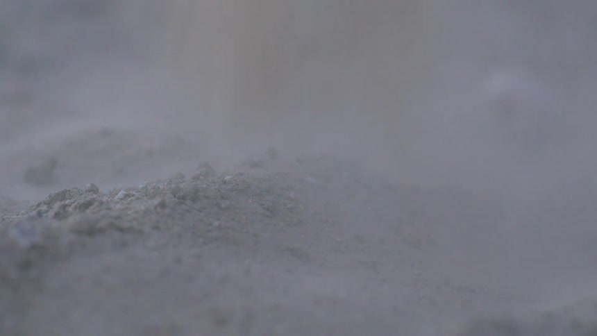 Closeup of sand falling on the ground