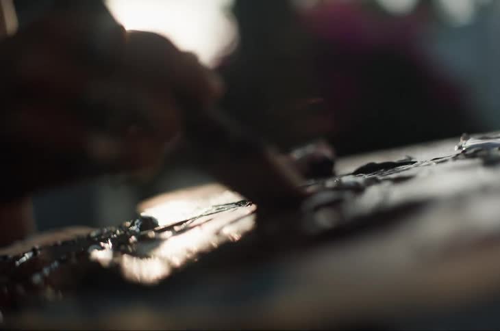 Brush being used to pick up paint from a support