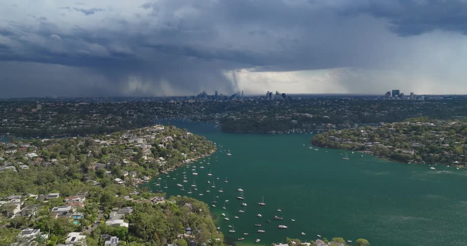Rain is pouring from the clouds in the city ahead