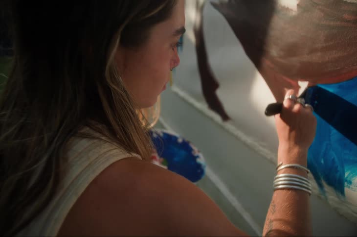 A woman is painting a mural on the wall